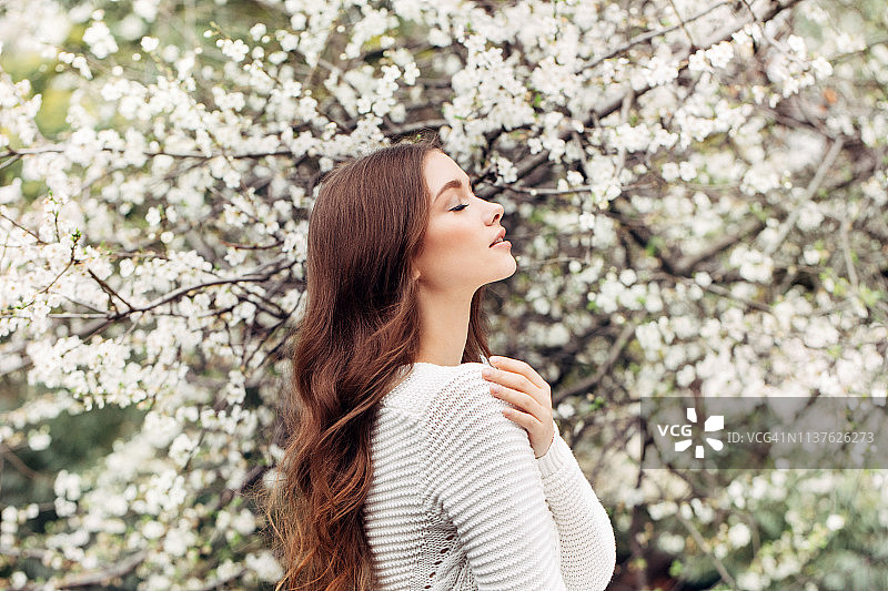 春天灌木丛背景上的美丽女孩图片素材