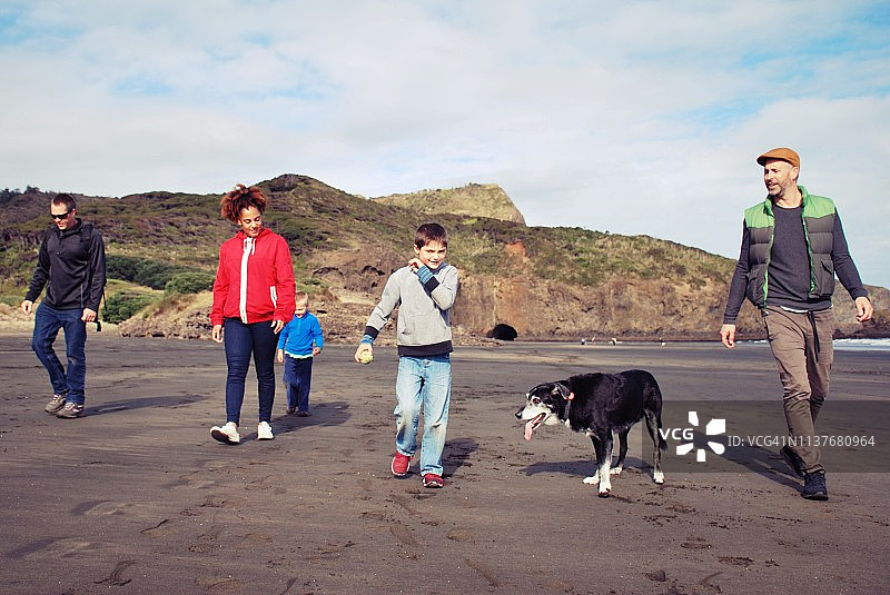 一家人和朋友在冬天于海滩遛狗图片素材