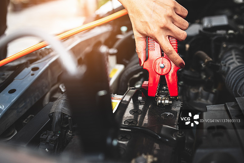 汽车修理工正在跨接启动汽车电池图片素材