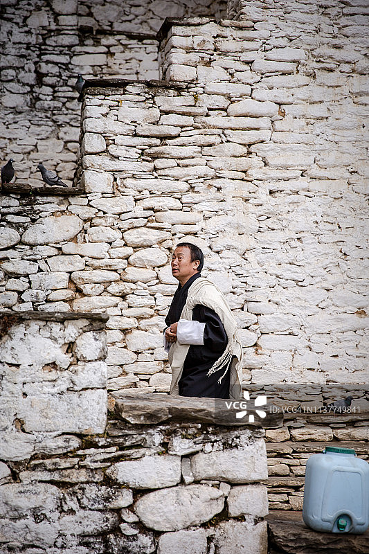 男子在不丹贾卡尔的楼梯上行走图片素材