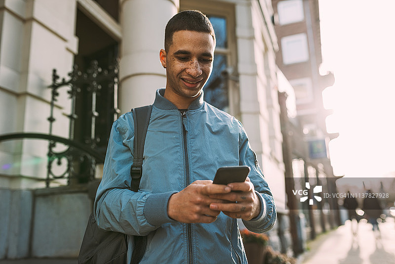 使用手机进行交流的拉丁裔千禧一代男人图片素材