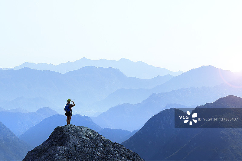 徒步女子拍摄日落美景图片素材