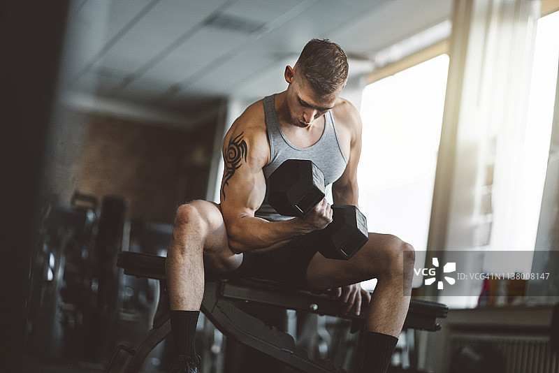健美运动员举重并展示肱二头肌图片素材