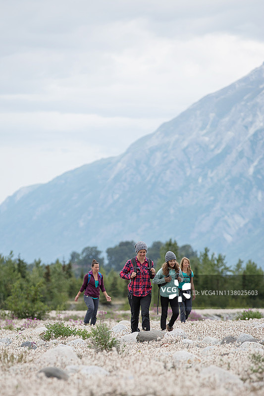 女孩和女人们徒步穿越鲜花盛开的草地图片素材