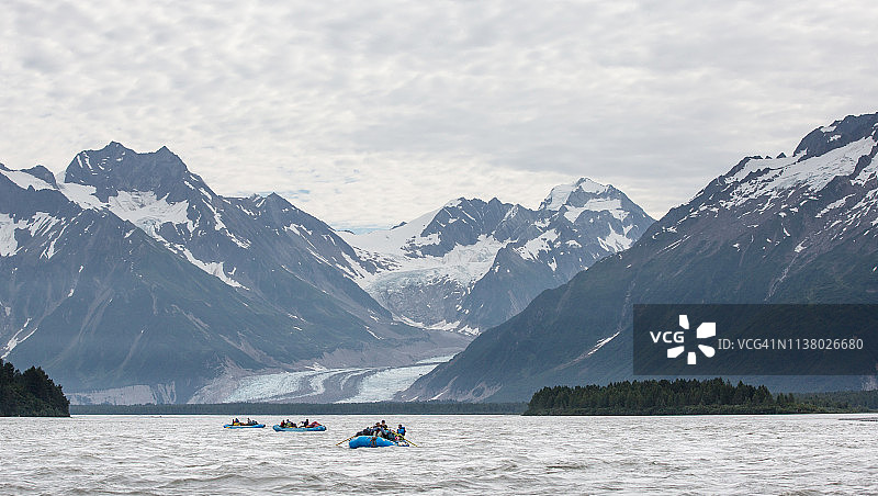 阿拉斯加山区中横渡宽阔河流的三个木筏图片素材