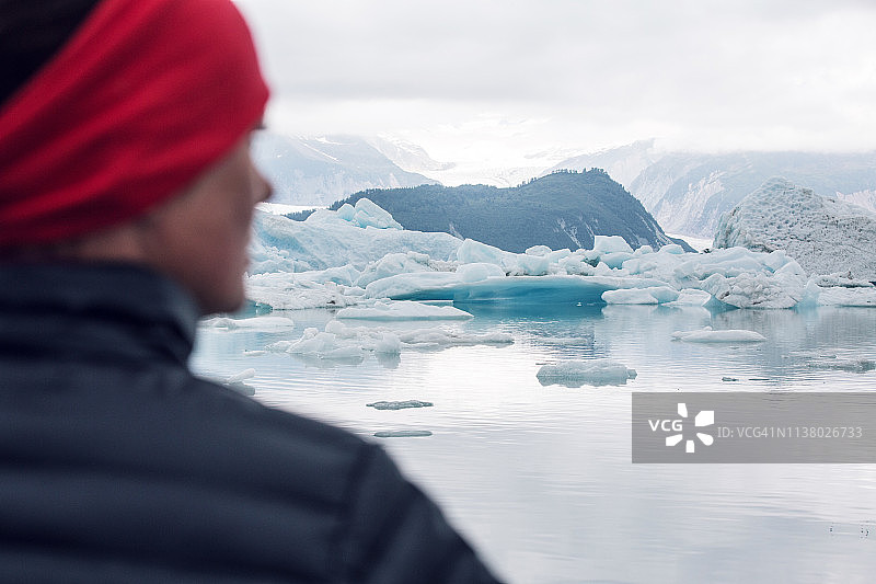 戴红色发带的女人凝视着冰川泻湖图片素材