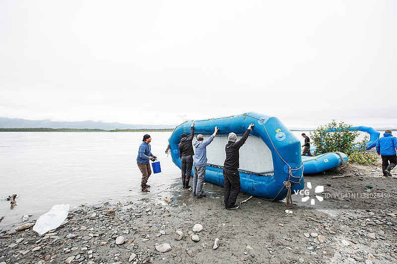 三人将木筏抬到一侧图片素材