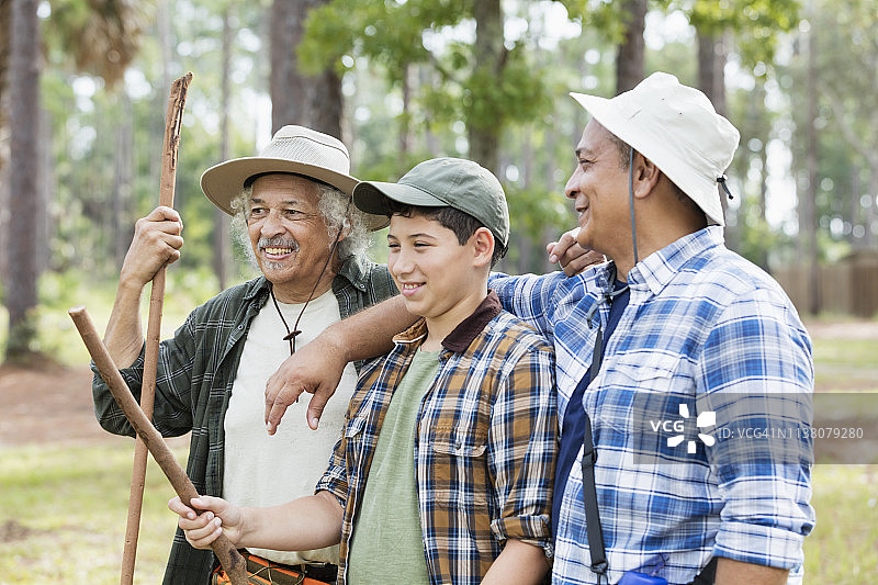 不同年龄段的西班牙裔家庭在树林里徒步旅行图片素材