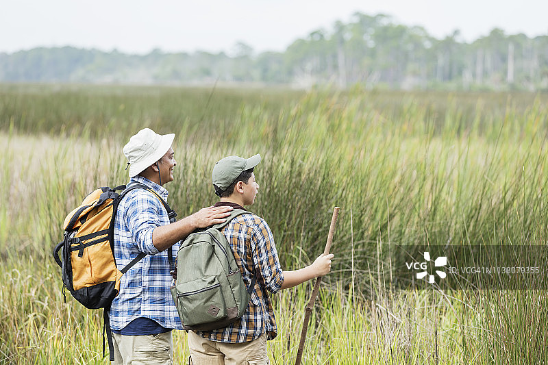 西班牙裔父子在公园湿地徒步旅行图片素材