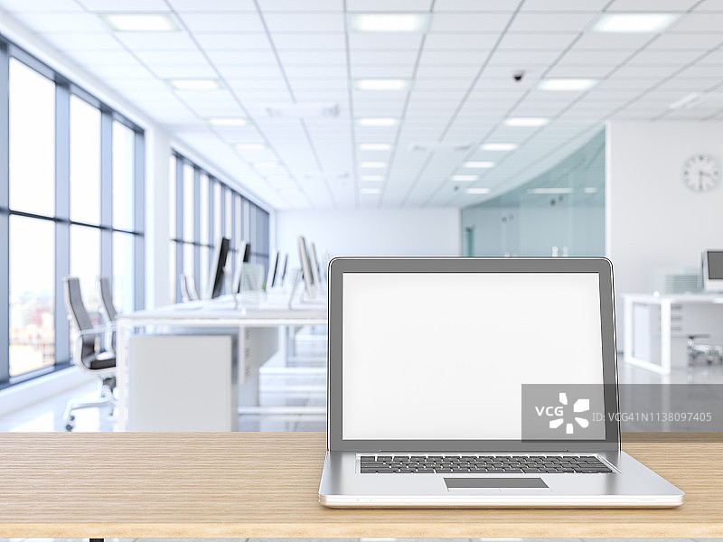 木质桌面和办公楼背景的笔记本电脑图片素材