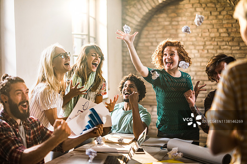 一群欢乐的企业家在办公室里庆祝成功时欢呼图片素材
