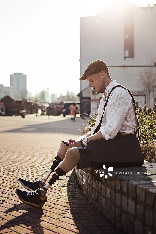 坐着发短信的残疾男子图片素材