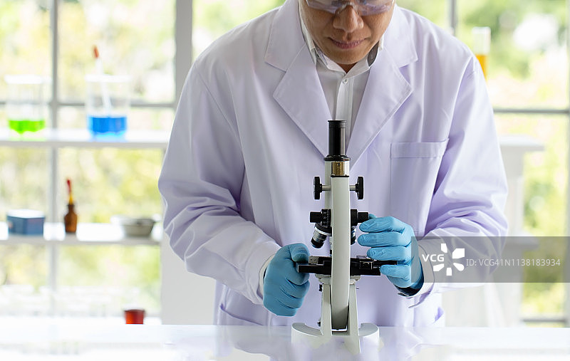科学家在实验室里用显微镜观察，进行研究图片素材