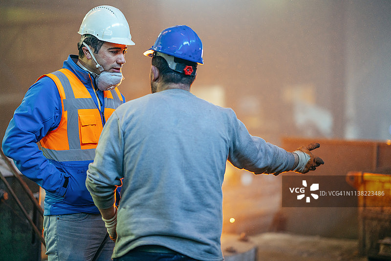 工程师和工人在铸造厂交谈图片素材