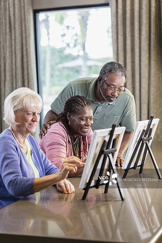非裔美国女人和朋友画画，配偶在一旁观看图片素材
