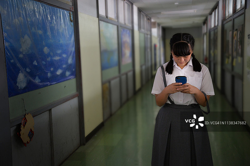 穿校服使用智能手机的少女图片素材