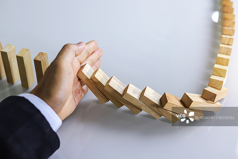商人放置木块于积木塔，风险控制图片素材