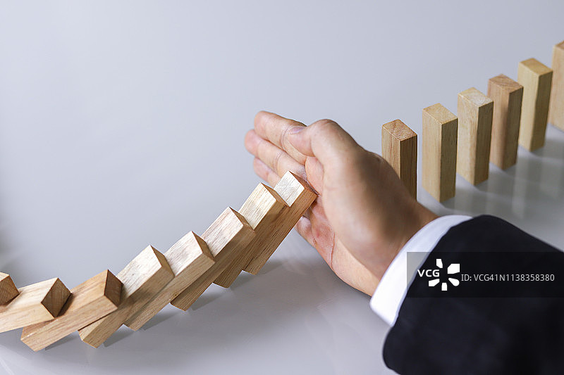 商人放置木块于积木塔，风险控制图片素材