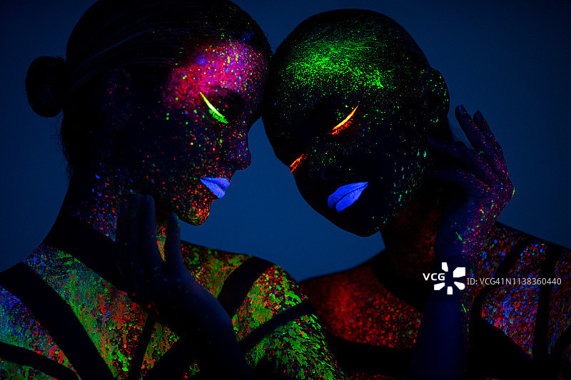 两个涂有荧光色的年轻女人图片素材