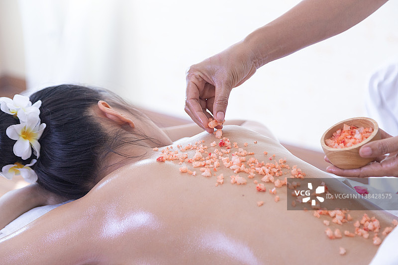 水疗中心年轻女子背部护理图片素材