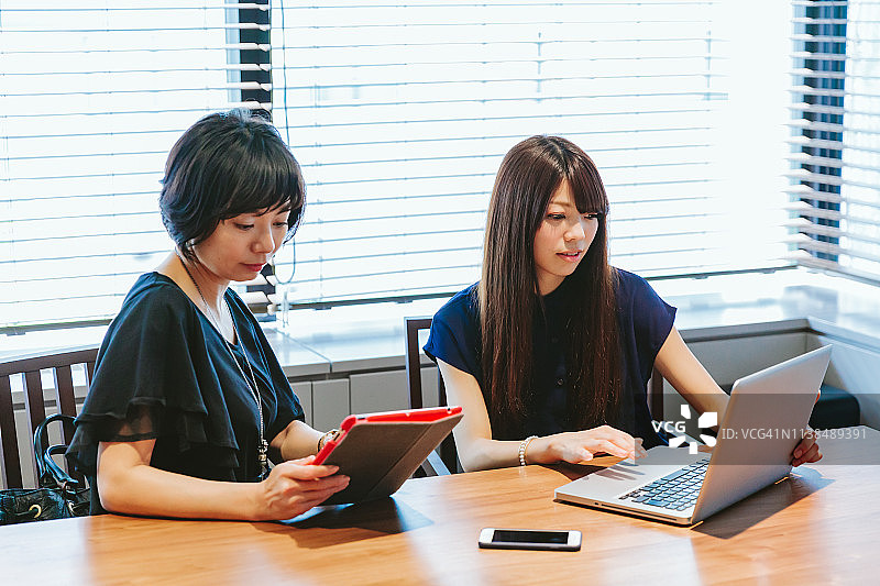 使用笔记本电脑和平板电脑工作的日本女商人图片素材