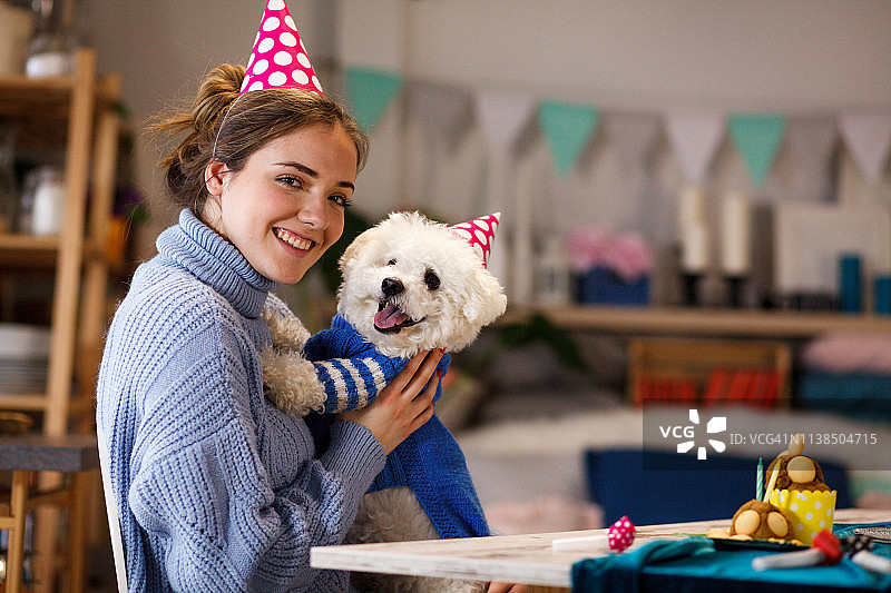 女孩用蛋糕庆祝小狗的生日图片素材