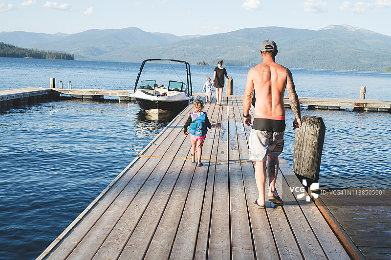 父亲和女儿走下码头去他们的船上图片素材