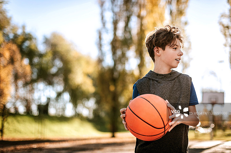 手拿篮球的青少年男孩图片素材