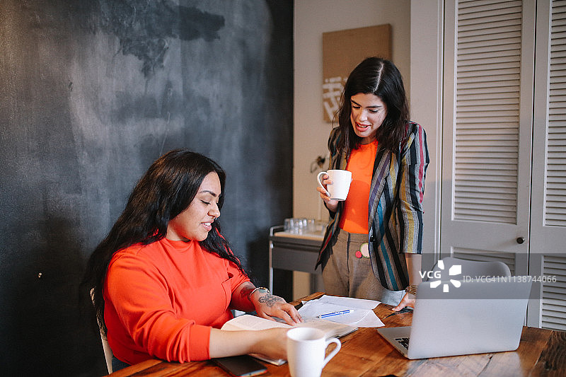 在洛杉矶市中心共享空间一起学习或工作到深夜的年轻女性图片素材
