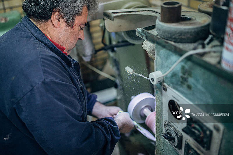 中年男人在制鞋厂的机器上工作图片素材
