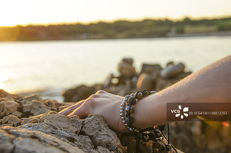 海边戴手镯的手图片素材