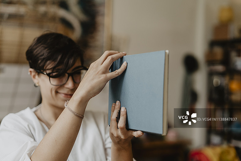 年轻女子看着笔记本的封面图片素材
