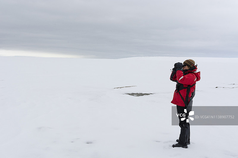 海洋探险号游轮自然向导在挪威斯瓦尔巴群岛Nordaustlandet和斯匹次卑尔根岛之间的Hinlopen海峡检查北极熊图片素材