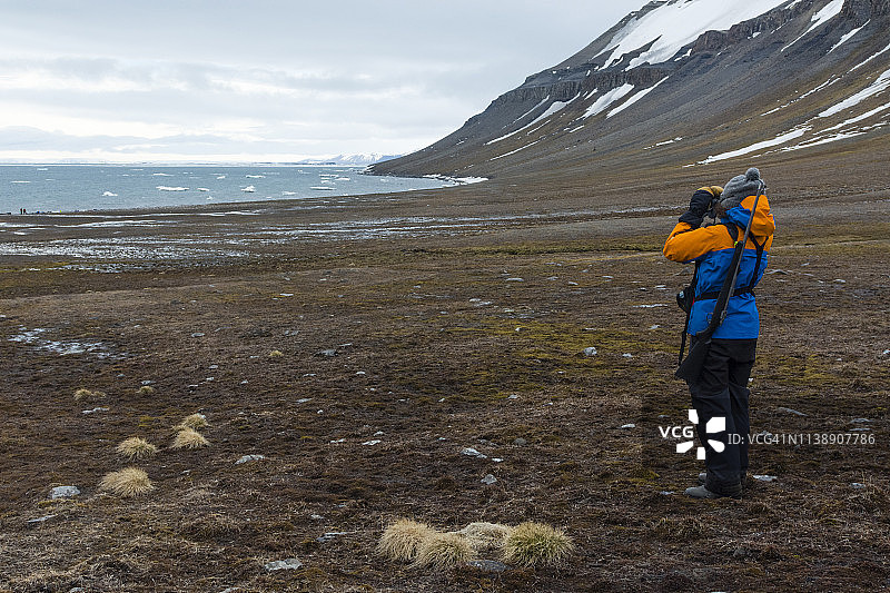 自然向导在斯瓦尔巴群岛埃ഡ്格岛检查周围区域，挪威图片素材