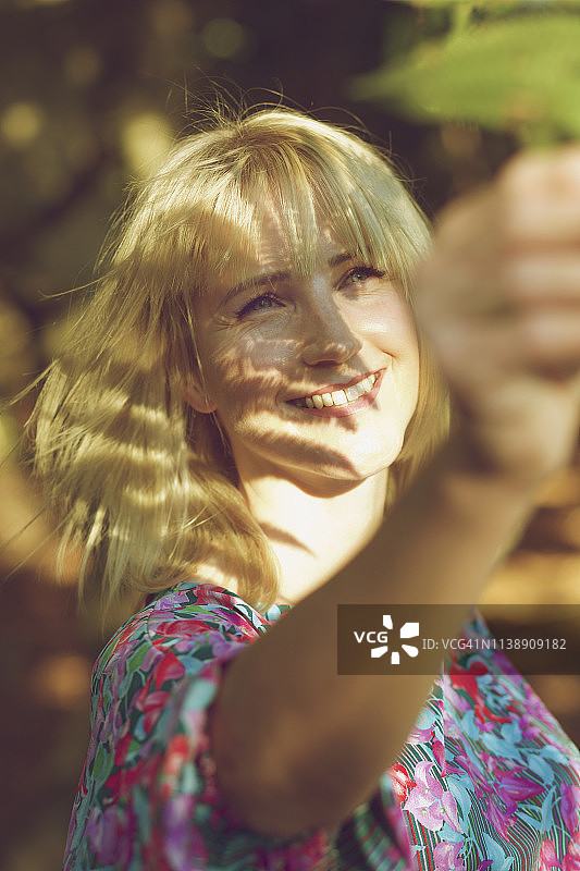 无忧无虑的女人伸手摘叶子图片素材