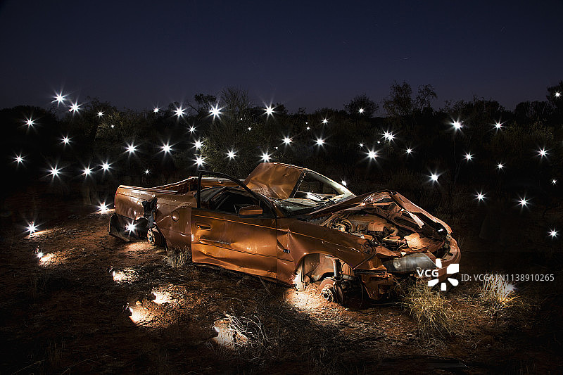 灯光照亮了被压扁的汽车艺术装置图片素材