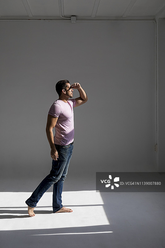 男子站在阁楼里，向窗外望去图片素材