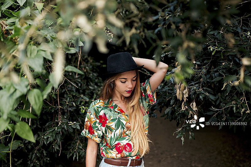 金发年轻女人身处树叶和自然之中图片素材