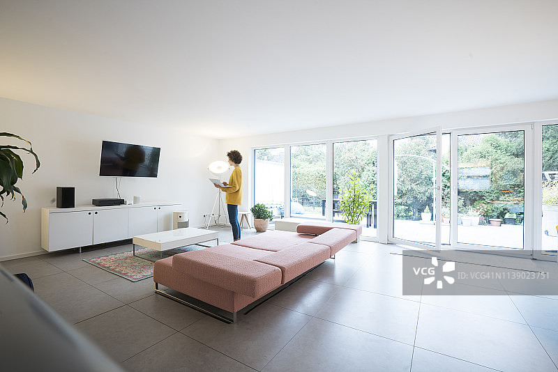 女人在家中宽敞的客厅里使用笔记本电脑图片素材