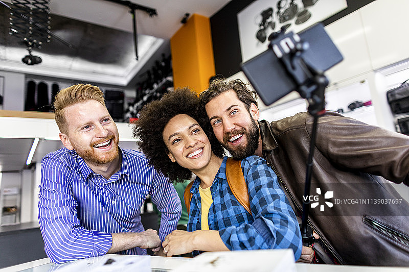 在摄影器材店自拍的购物情侣和商家图片素材