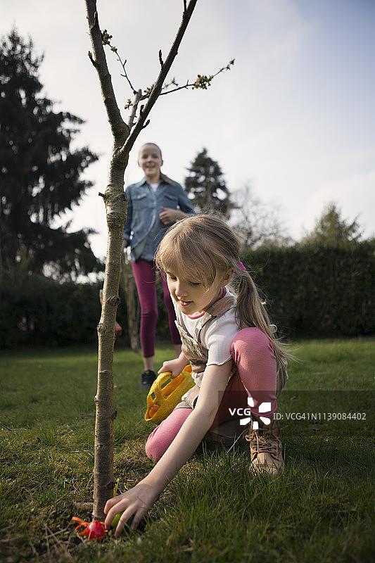 两个孩子在后院寻找复活节彩蛋图片素材