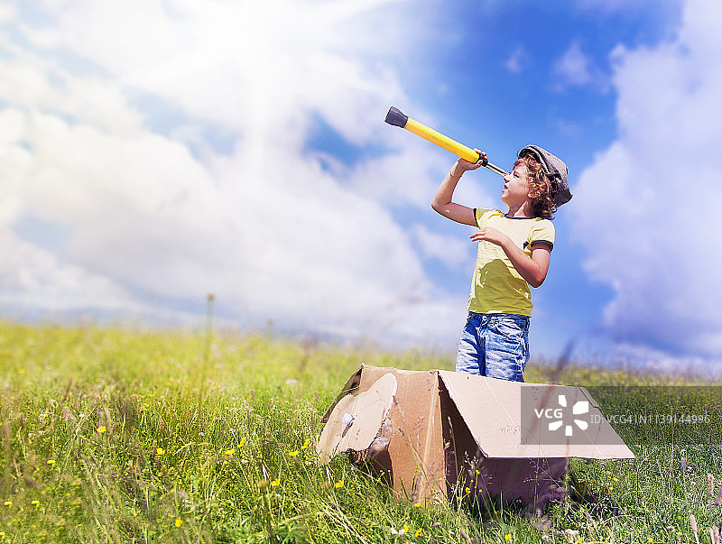 男孩用单筒望远镜观察图片素材