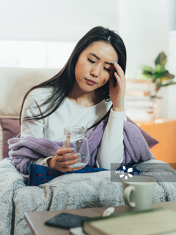 年轻的亚洲女性在家生病图片素材
