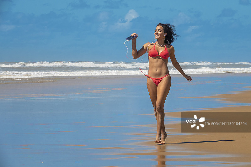 在海滩听音乐的巴西青少年图片素材