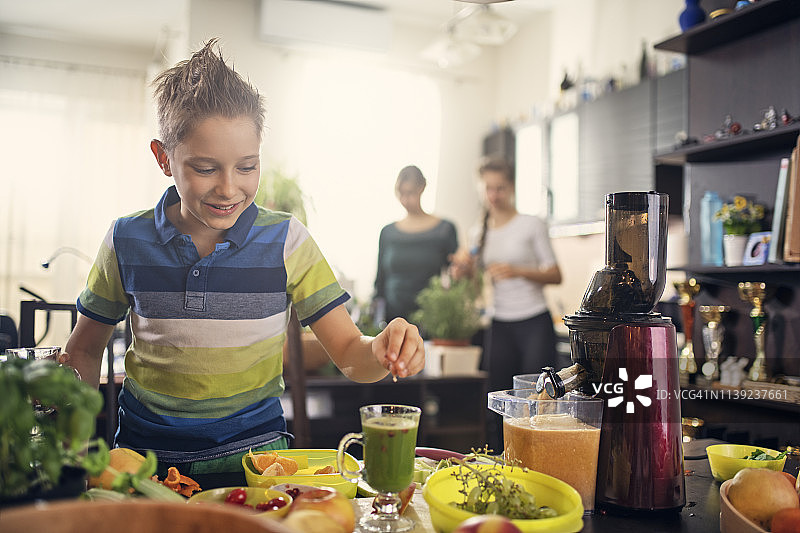 小男孩用果蔬装饰纯素果汁图片素材