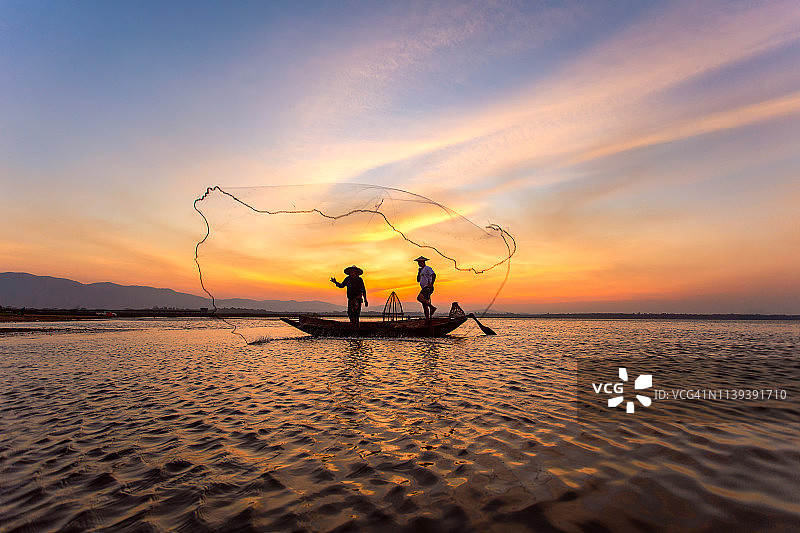 日落时分湖上渔民剪影图片素材