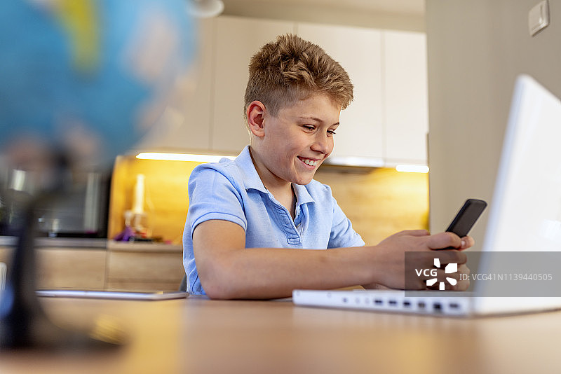 在家用智能手机发短信的男孩图片素材