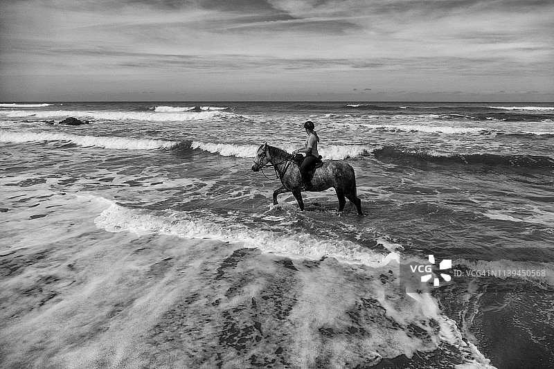 女人在海滩上骑马图片素材