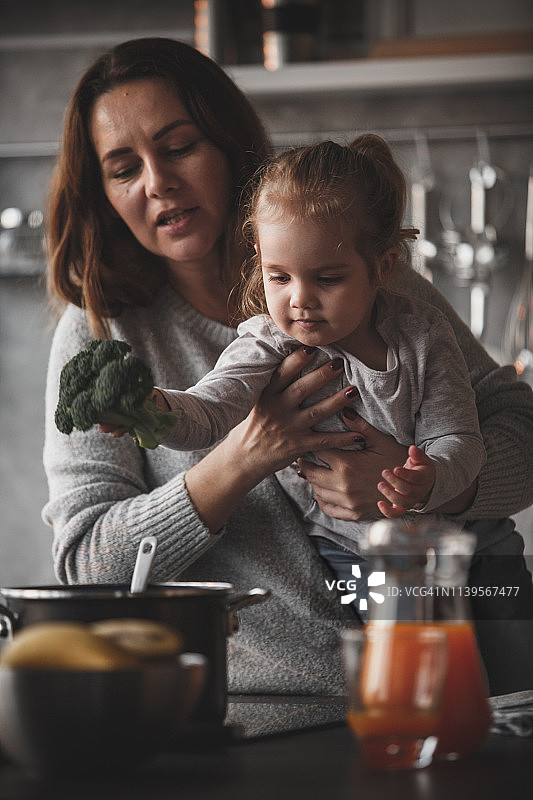 小女孩将西兰花放入锅中图片素材