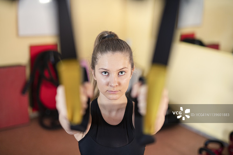 身穿EMS训练服的女子在健身房进行悬挂训练图片素材
